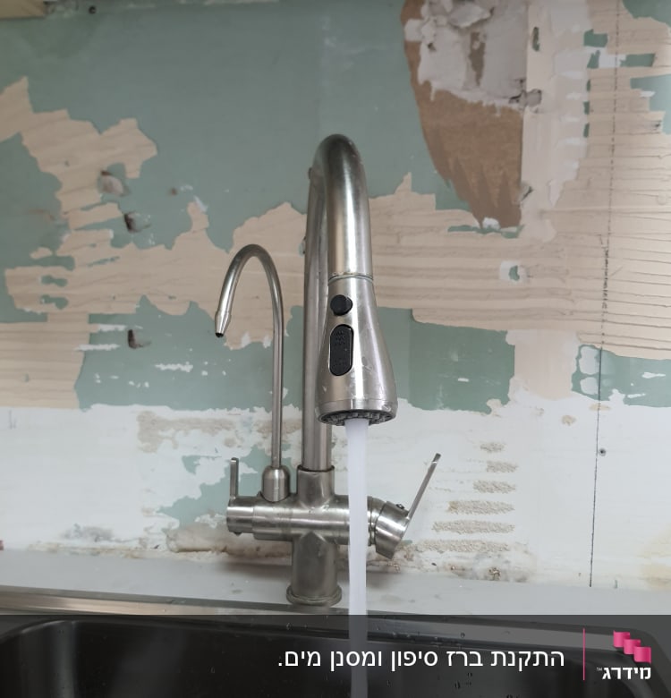 ברז נירוסטה עם מים זורמים בכיור מטבח